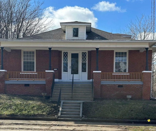 bungalow-style house with crawl space, covered porch, and brick siding