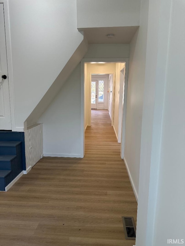 additional living space with lofted ceiling, baseboards, visible vents, and wood finished floors