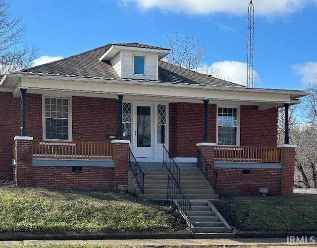 bungalow-style home featuring a porch, brick siding, and a front lawn