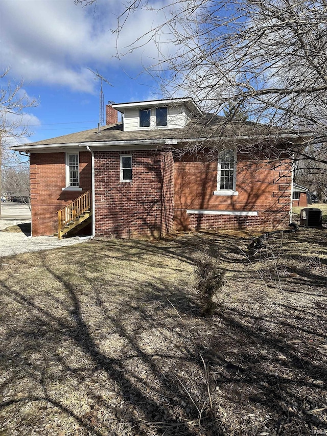 rear view of property featuring brick siding and cooling unit