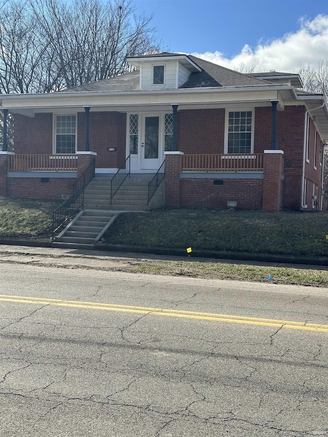 view of front of property featuring brick siding and a porch