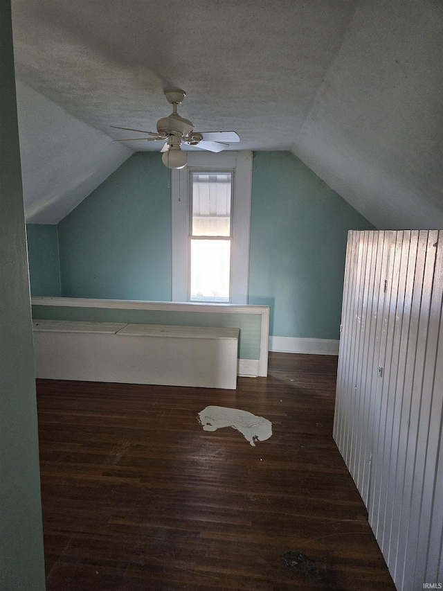 bonus room with a textured ceiling, ceiling fan, lofted ceiling, wood finished floors, and baseboards