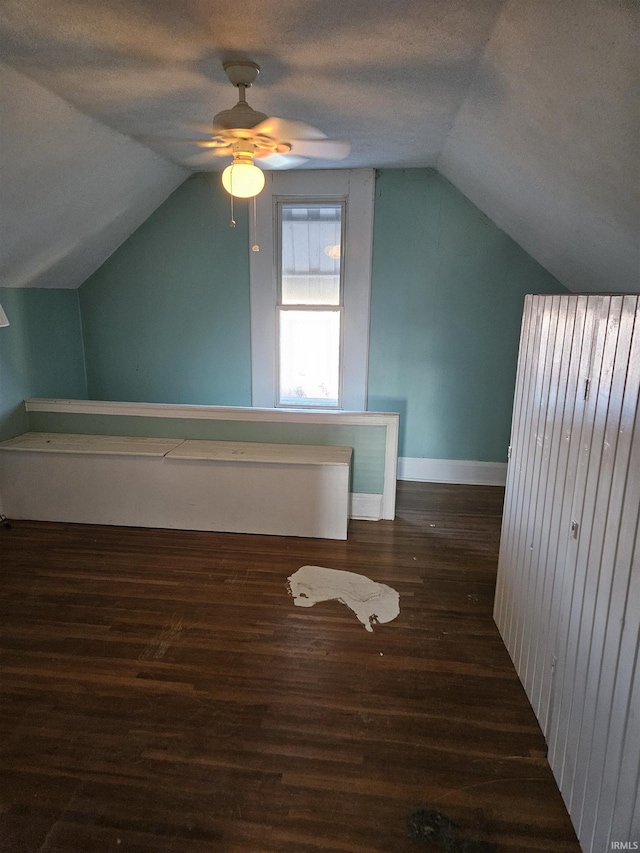 bonus room with lofted ceiling, a textured ceiling, baseboards, and wood finished floors