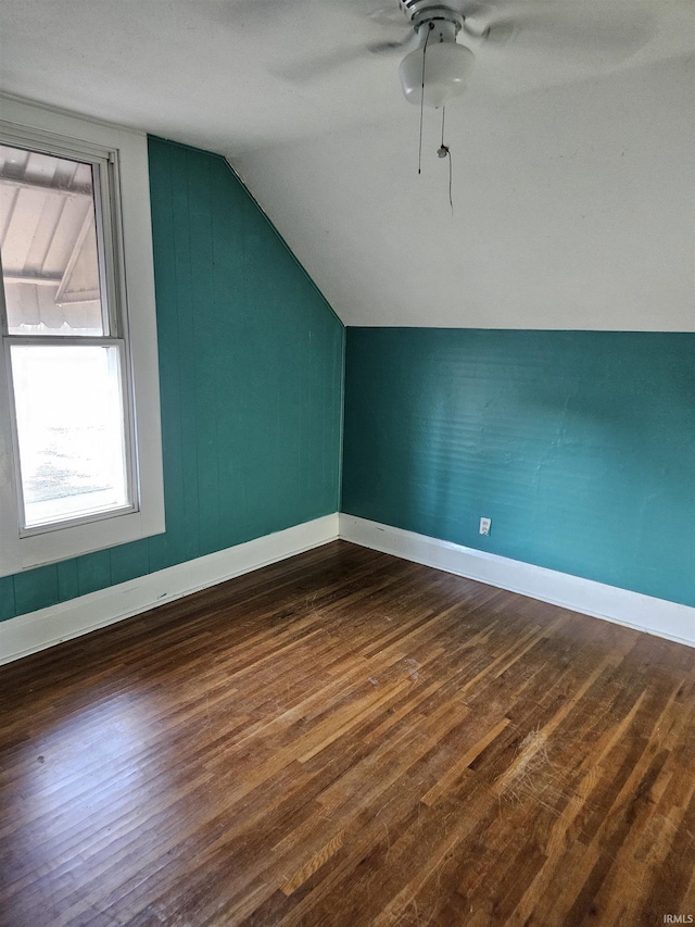 bonus room with lofted ceiling, a ceiling fan, baseboards, and dark wood-style flooring