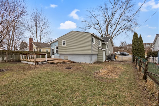 rear view of house featuring a lawn, a fenced backyard, and a wooden deck