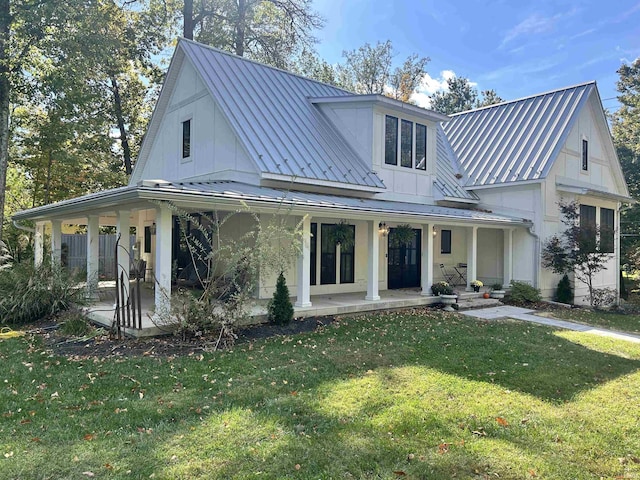 modern inspired farmhouse with metal roof, a front lawn, a standing seam roof, and a patio area