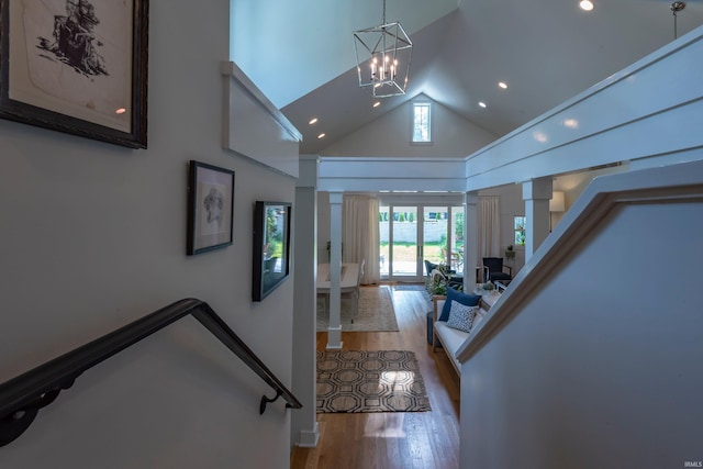 hall featuring a notable chandelier, recessed lighting, stairway, wood finished floors, and high vaulted ceiling