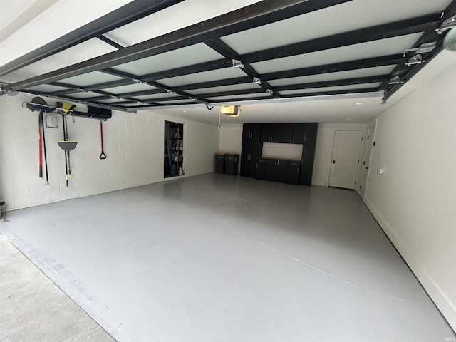 garage with concrete block wall and a garage door opener