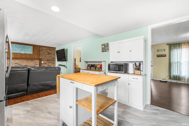 kitchen featuring open floor plan, stainless steel appliances, and white cabinetry