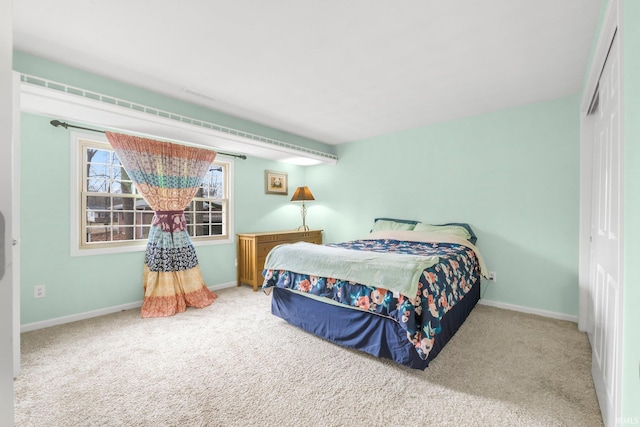 carpeted bedroom with baseboards and a closet