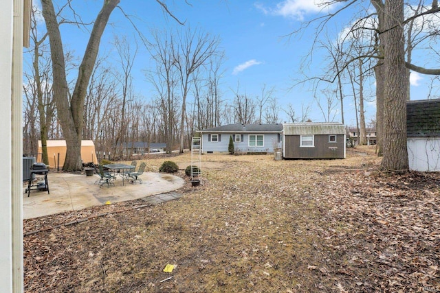 back of house with a patio, an outdoor structure, and a storage unit