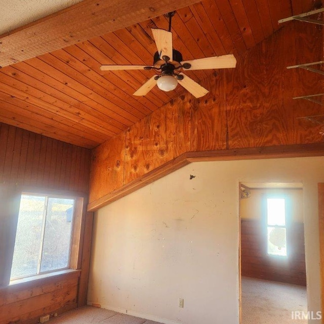 spare room featuring wooden ceiling, vaulted ceiling, wood walls, and ceiling fan