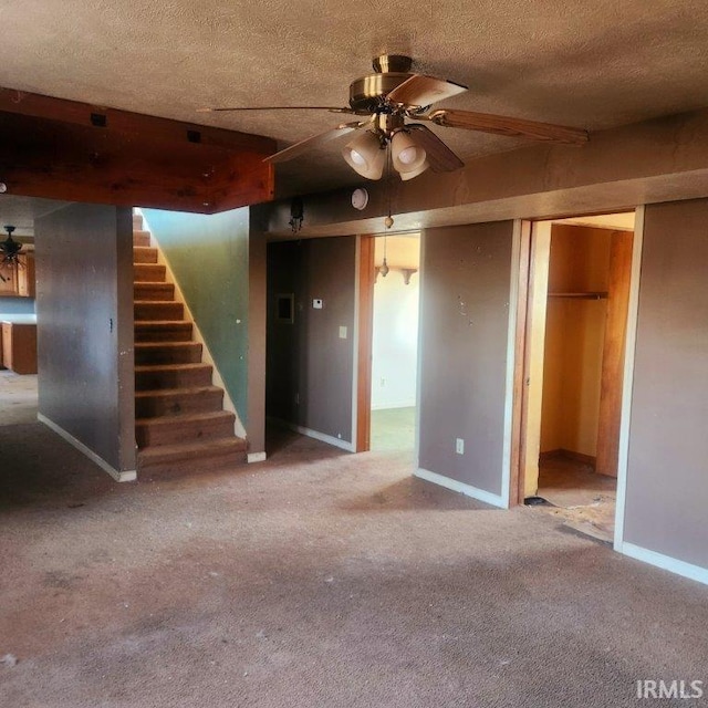 interior space featuring baseboards, ceiling fan, stairs, a textured ceiling, and carpet flooring