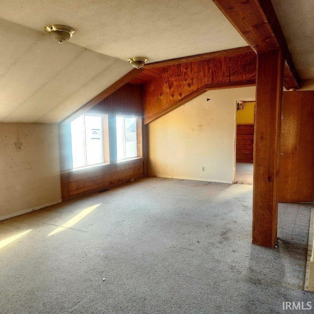 bonus room featuring lofted ceiling, carpet floors, and a textured ceiling