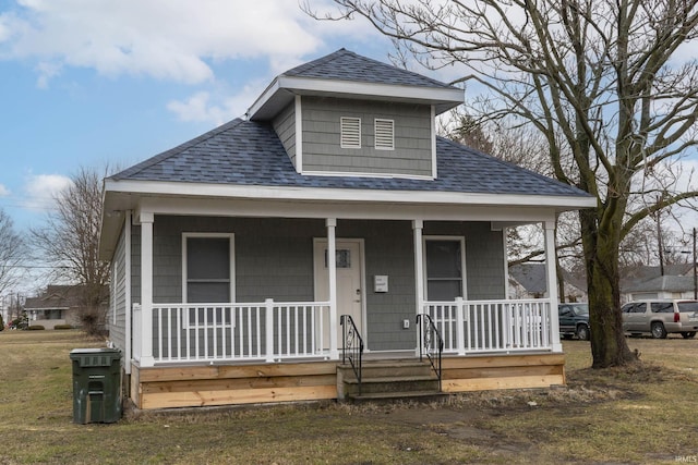 bungalow with covered porch and a shingled roof