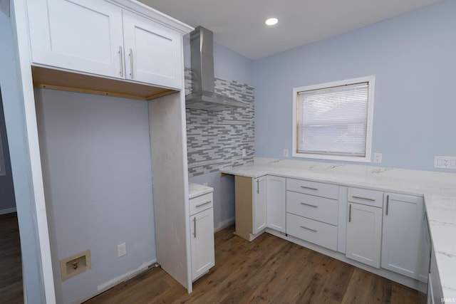 interior space featuring wall chimney range hood, tasteful backsplash, dark wood-style floors, and light stone counters