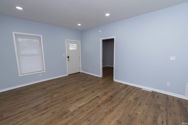 spare room with recessed lighting, visible vents, dark wood finished floors, and baseboards