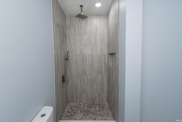 full bathroom featuring toilet and a tile shower