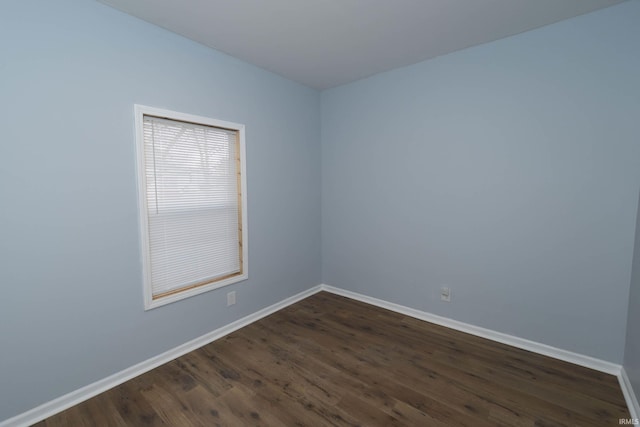 empty room featuring dark wood finished floors and baseboards