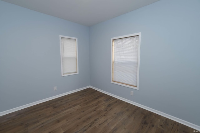 unfurnished room with dark wood finished floors and baseboards