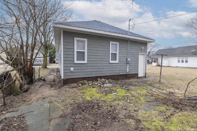 view of side of home with a shingled roof