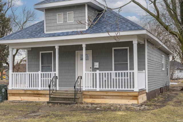 bungalow-style home with covered porch and roof with shingles