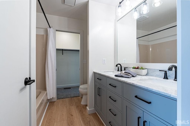 full bathroom featuring visible vents, a sink, toilet, and wood finished floors