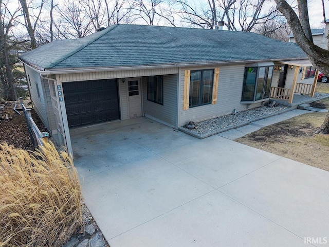 single story home with driveway, roof with shingles, and an attached garage