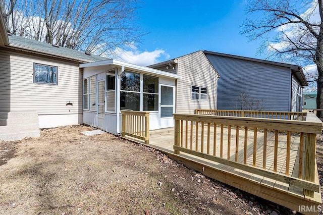 back of property featuring a sunroom and a wooden deck