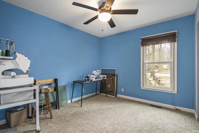 carpeted home office with a ceiling fan, visible vents, and baseboards