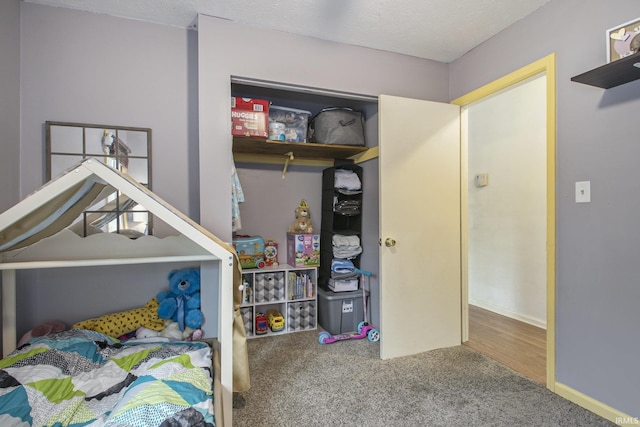 carpeted bedroom with a textured ceiling and baseboards