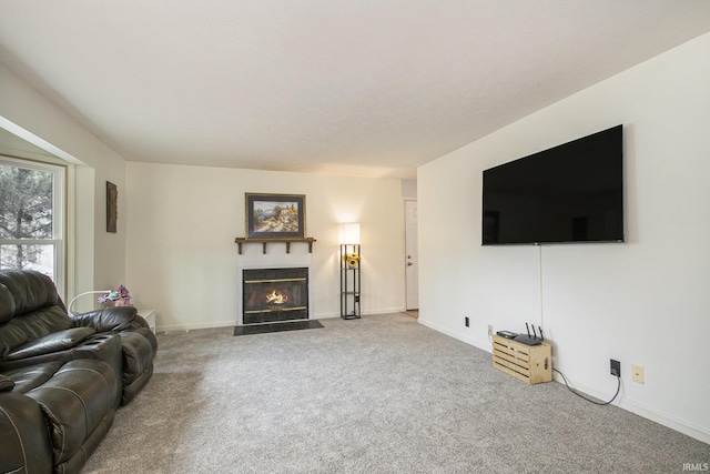 carpeted living area featuring a fireplace with flush hearth and baseboards