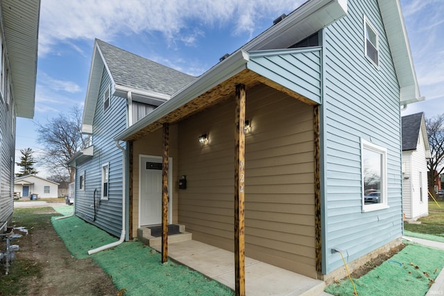 view of home's exterior featuring a shingled roof and entry steps