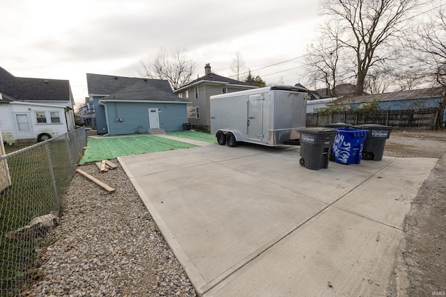 back of property featuring a fenced backyard, roof with shingles, a patio, and an outdoor structure