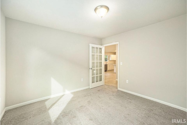 unfurnished room featuring baseboards, carpet flooring, and french doors