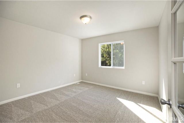 empty room featuring carpet flooring and baseboards