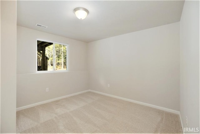 unfurnished room with carpet, visible vents, and baseboards