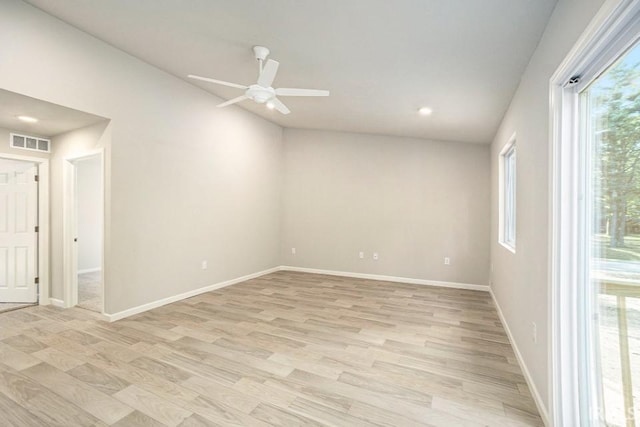 unfurnished room featuring light wood-type flooring, visible vents, lofted ceiling, and baseboards