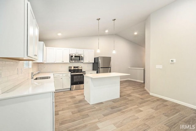 kitchen with light wood finished floors, appliances with stainless steel finishes, a sink, and a center island