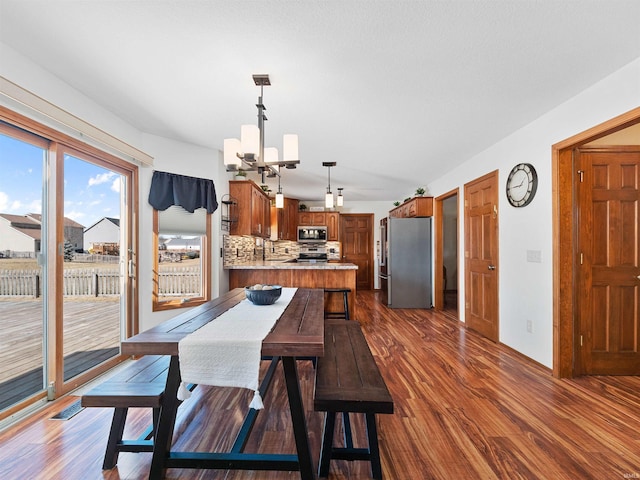 dining area featuring dark wood-style flooring and a notable chandelier