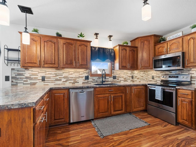 kitchen with dark wood-style floors, appliances with stainless steel finishes, decorative backsplash, and a sink