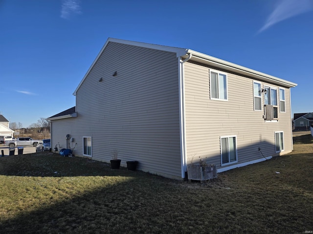 view of side of property featuring a lawn and central air condition unit