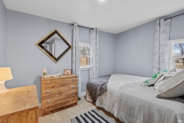 bedroom with carpet floors and multiple windows