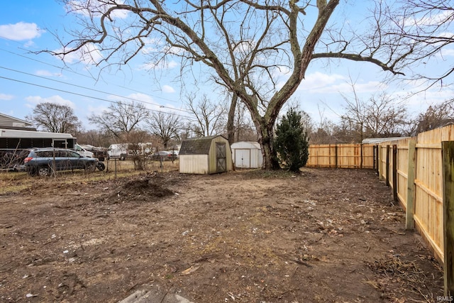 view of yard with a shed, a fenced backyard, and an outdoor structure