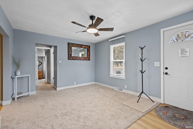 foyer entrance featuring carpet floors, baseboards, visible vents, and ceiling fan