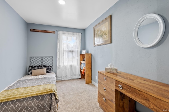 bedroom with a textured wall, carpet, and baseboards