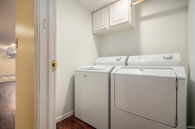 washroom with cabinet space, baseboards, separate washer and dryer, and dark wood-style flooring