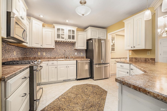 kitchen featuring light tile patterned floors, white cabinetry, stainless steel appliances, and a sink