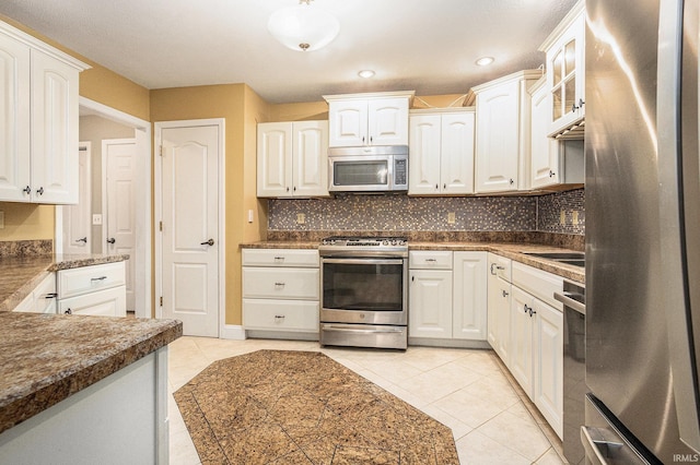 kitchen featuring light tile patterned floors, recessed lighting, backsplash, appliances with stainless steel finishes, and white cabinetry