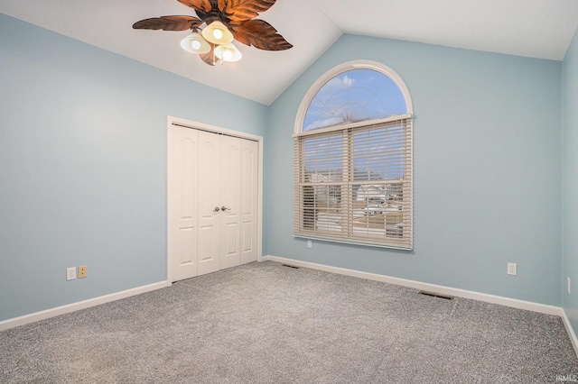 unfurnished bedroom featuring lofted ceiling, a closet, visible vents, carpet flooring, and baseboards